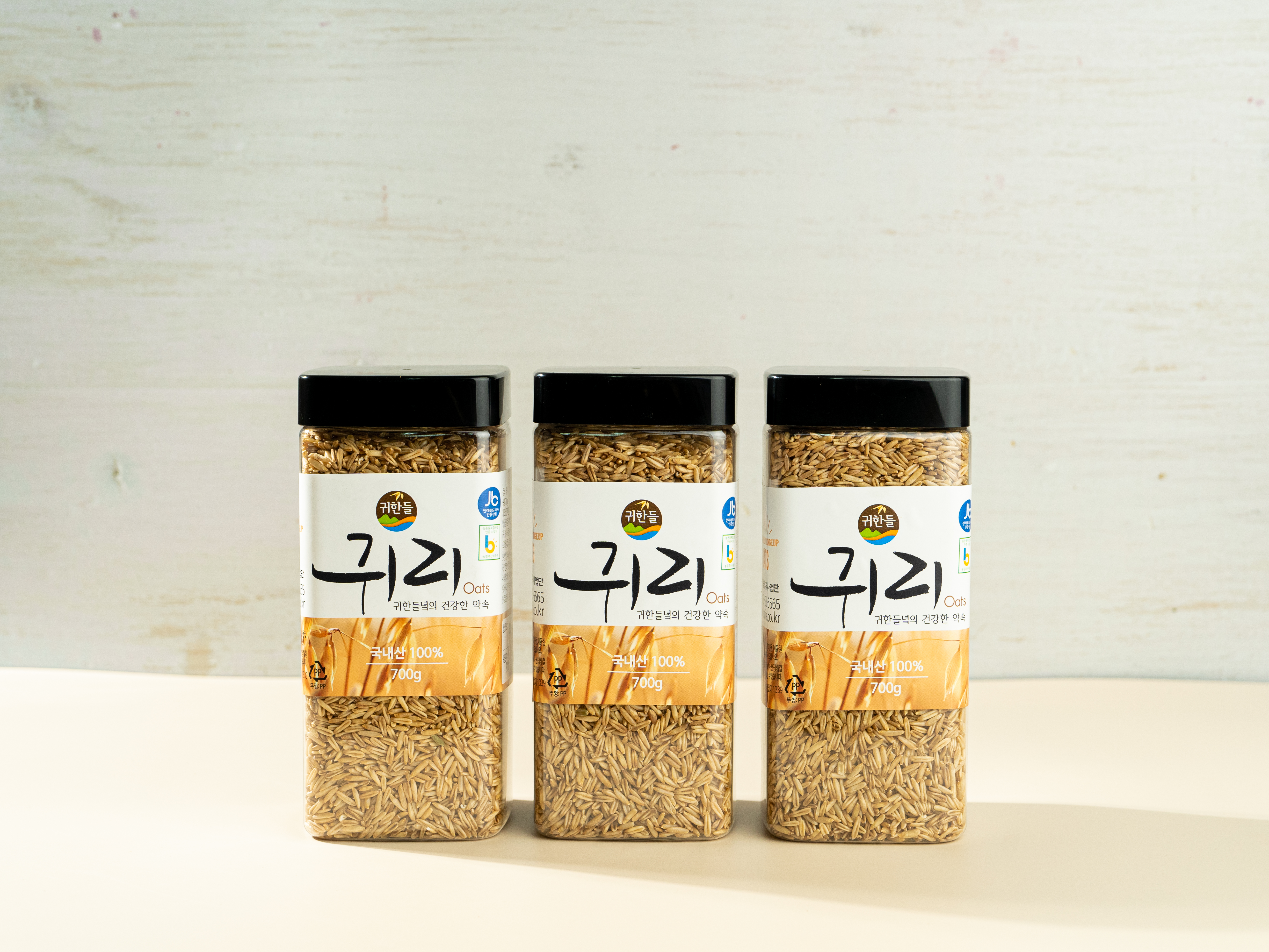 밝은 배경 위에 균형 있게 배열된 700g 용기 3개로 구성된 정읍명품귀리 선물세트